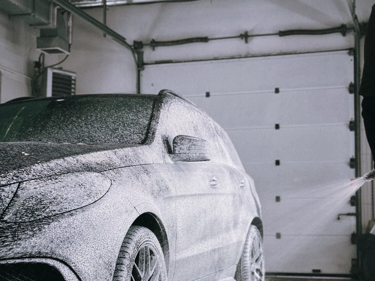 Luxury SUV foam-washed in a South Florida detailing bay